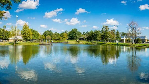 A stocked fishing pond surrounded by trees and visitor facilities at the Texas Freshwater Fisheries Center in Athens, Texas.