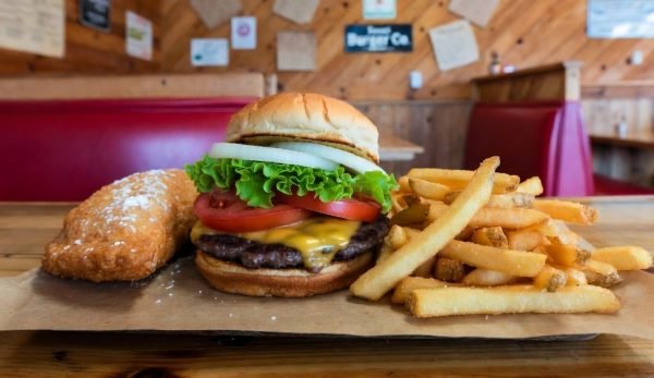 A large cheeseburger with hand-cut fries and a fried pie served inside a rustic East Texas restaurant.